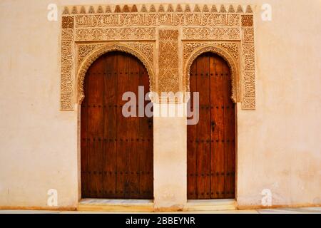 Granada, Spanien: Nahaufnahme von zwei Holztüren und einem dekorativen Wandteil des Innenhofs der Myrtles (Patio de los Arrayanes) Stockfoto