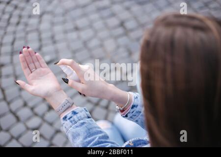 Nahaufnahme der Hand der Frau. Frauen in der Maske verwenden Desinfektionsmittel Stockfoto