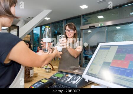 Female Shop Assistant ein Kunde an einem Schreibtisch. Stockfoto