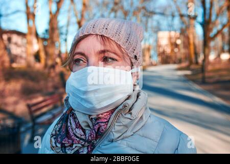 Frau, die die Gesichtsmaske trägt, um eine Virusinfektion zu vermeiden und die Ausbreitung der Krankheit zu verhindern. Vireninfektionsschutz. Echte Menschen, authentische Situatio Stockfoto