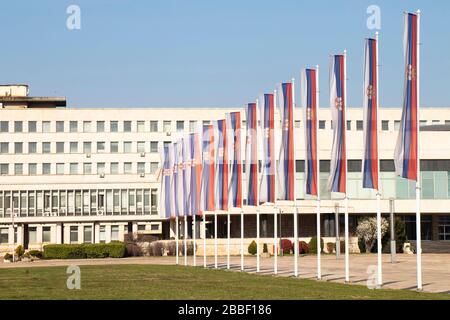 Belgrad, Serbien - 20. März 2020: Serbische Nationalflaggen auf Pfosten vor dem Palast Serbiens, Regierungsgebäude 1951 fertiggestellt, die LARG Stockfoto