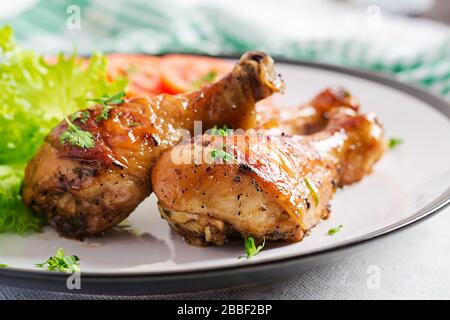 Gegrillte Hühnerbeine mit Gewürzen und frischem Gemüse. Gebackene Trommeln. Stockfoto