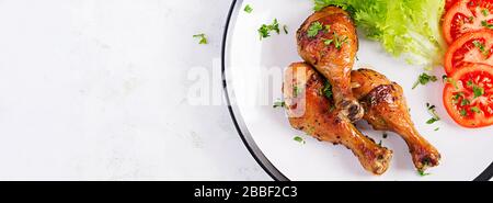 Gegrillte Hühnerbeine mit Gewürzen und frischem Gemüse. Gebackene Trommeln. Draufsicht, Banner Stockfoto