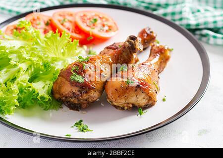 Gegrillte Hühnerbeine mit Gewürzen und frischem Gemüse. Gebackene Trommeln. Stockfoto