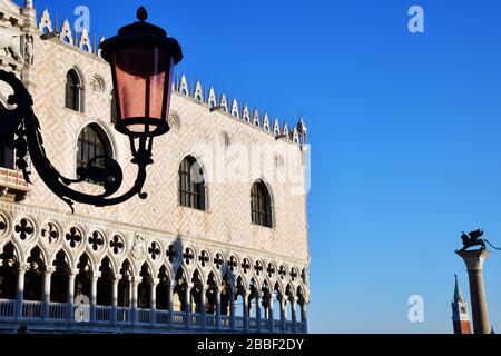 Venedig, Italy-Februar 2020; Tiefwinkelansicht der Fassade des Dogenpalastes in der späten Nachmittagsonne mit Silhoutte einer Lampe und Statuen in der BA Stockfoto