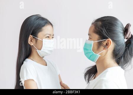 Mutter und Tochter tragen eine medizinische Schutzmaske. Schutz vor Grippeepidemie, Coronavirus oder COVID-19 und Smog-Krankheit Stockfoto
