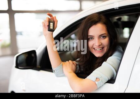 Ein Autoverkäufer übergibt einem Kunden den Schlüssel für ein neues Auto Stockfoto