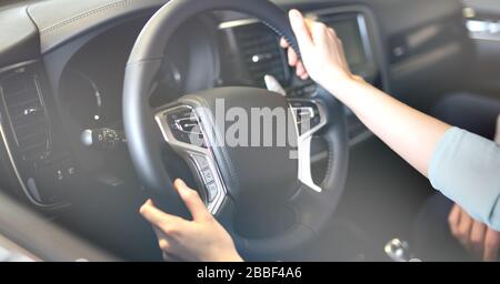 Mann und Frau in einem Autohaus, der ein Auto kauft, Käufer und Verkäufer Stockfoto