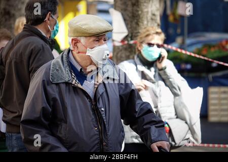 Menschen auf dem Markt, mit Gesichtsmasken zum Schutz vor COVID-19. Turin, Italien - März 2020 Stockfoto