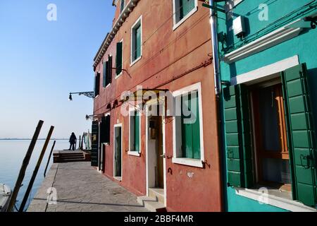 Venedig, Italy-Februar 2020; Tiefblick auf einen Abschnitt eines historischen Gebäudes in Burano in der Nähe von Venedig in etwas verblassten Farben mit Blau Stockfoto