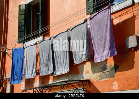 Venedig, Italy-Februar 2020; Nahaufnahme eines Abschnitts eines der alten Gebäude in Burano in der Nähe von Venedig mit farbenfroher Fassade und Wäscherei Stockfoto