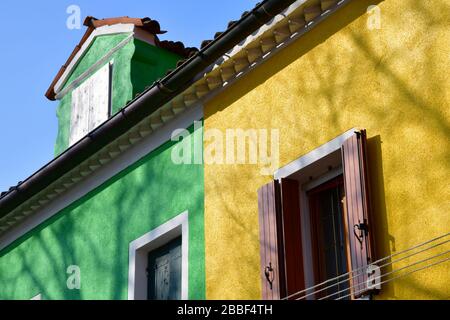 Venedig, Italy-Februar 2020; Nahaufnahme eines Abschnitts eines der alten Gebäude in Burano in der Nähe von Venedig mit bunter Fassade in Grün und Gelb Stockfoto