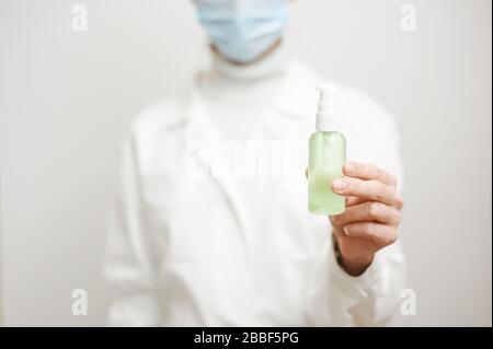 Nahaufnahme der Hände von Ärztinnen, die ein persönliches Antiseptikum oder Desinfektionsmittel zeigen. Covid-19 Schutzmaßnahmen. Doktor in weißem medizinischen Gown bei Clea Stockfoto