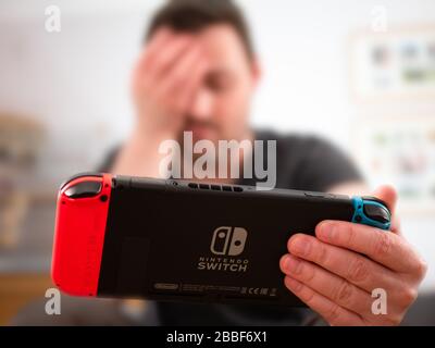 Großbritannien, März 2020: Nintendo Switch Spielekonsolen-Gamer mit Kopf in den Händen, nachdem sie das Spiel enttäuscht verloren haben Stockfoto