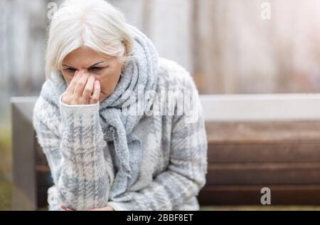 Ältere Frau, die an Kopfschmerzen leidet Stockfoto