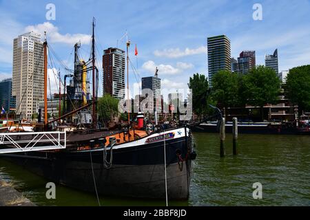 Rotterdam, Niederlande; Nahaufnahme einer Reihe historischer Flussbargen, die im Oudehaven in Rotterdam mit modernem Hochhaus verlandet sind Stockfoto