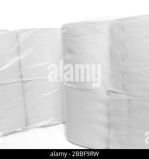 Zwei Packungen mit in Kunststoff verpacktem toilettenpapier sitzen nebeneinander vor weißem Hintergrund. Stockfoto