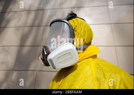 Rettungssanitäter tragen gelbes Schutzkostüm und maskieren desinfizierendes Coronavirus Stockfoto