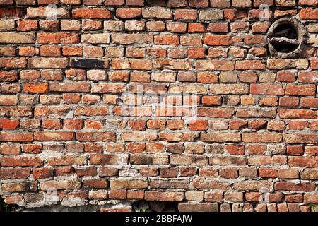 Die baufällige alte Ziegelmauer aus rotem Backstein Stockfoto