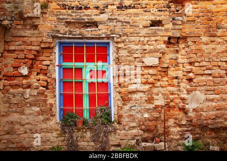 Fenster in einer alten Ziegelmauer in einem verlassenen Haus Stockfoto
