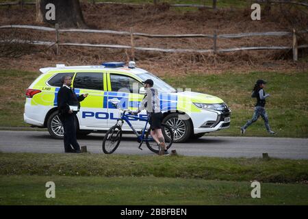 Eine Polizeipatrouille hält an, mit einem Radfahrer im Richmond Park in Richmond upon Thames, im Südwesten Londons zu sprechen, da Großbritannien weiterhin in Sperrniederlegung ist, um die Ausbreitung des Coronavirus einzudämmen. Stockfoto