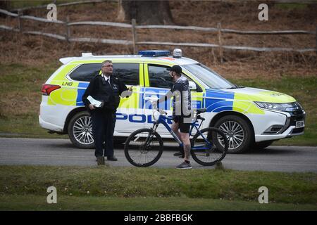 Eine Polizeipatrouille hält an, mit einem Radfahrer im Richmond Park in Richmond upon Thames, im Südwesten Londons zu sprechen, da Großbritannien weiterhin in Sperrniederlegung ist, um die Ausbreitung des Coronavirus einzudämmen. Stockfoto