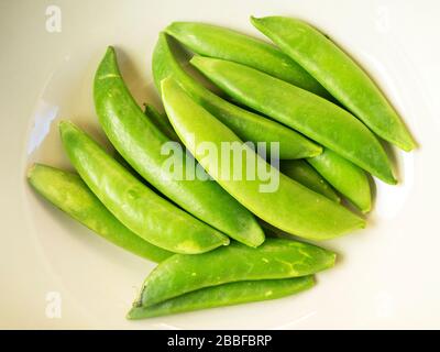 Portion frischer grüner Zuckererbsen in einer Schüssel Stockfoto