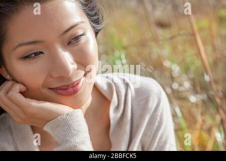 Porträt einer schönen jungen chinesischen Asian Oriental Frau ruht auf ihrer hand Stockfoto