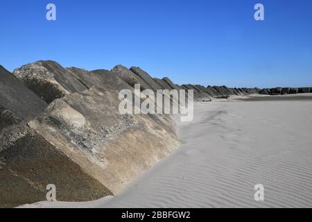 Blick auf eine lange Reihe extrem großer Betonblöcke, die als Wellenbrecher am Strand Maasvlakte bei Rotterdam dienen Stockfoto