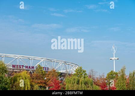 West Ham United's Home Ground und ehemaliges Olympiastadion 2012 das Londoner Stadion, sichtbar durch Herbstbäume im Queen Elizabeth Olympic Park Stockfoto