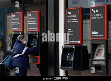 Birmingham, West Midlands, Großbritannien. März 2020. Eine Frau verwendet einen HSBC Bank-Geldpunkt in der Innenstadt von Birmingham während der Pandemie-Sperrzeit von Coronavirus. Credit Darren Staples/Alamy Live News. Stockfoto