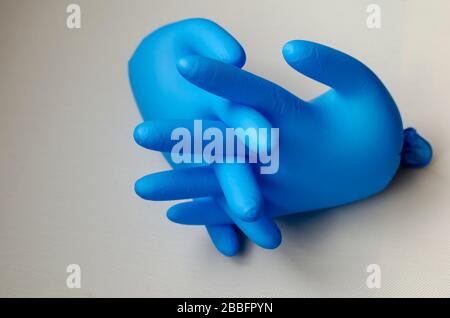 Aufgeblasene blaue medizinische Handschuhe. Ein Paar Schutzhandschuhe mit verschlossenen Fingern. Latexblaue Handschuhe auf Netzhintergrund. Selektiver Fokus. Nahaufnahme. Stockfoto