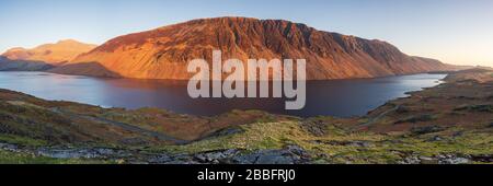 Illgill Head, auch bekannt als The Screes, leuchtet im letzten Licht eines Frühlingstages rot über den dunkelblauen Tiefen von Wast Water, Lake District, Großbritannien. Stockfoto