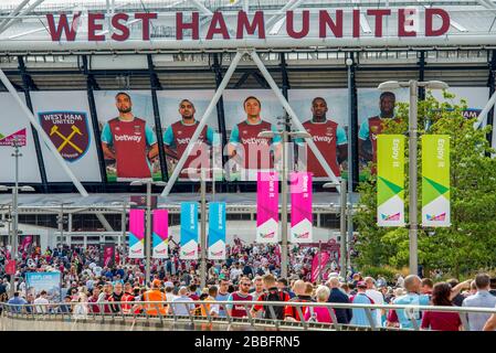 Bunte Menschenmassen von Fußballfans gehen in das Londoner Stadion, das die Heimat des West Ham United Football Club im Olympic Park East London ist. Stockfoto