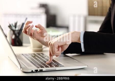 Nahaufnahme der wütenden Frau, die die Executive-Hände mit einer harten Laptop-Taste auf einem Schreibtisch im Büro drückt Stockfoto