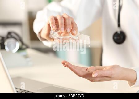 Nahaufnahme der Ärztin mit Händededesinfektionsmittel im Büro Stockfoto