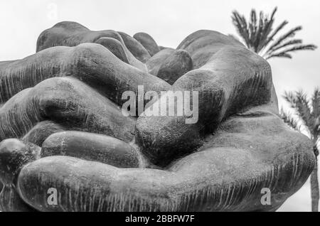 ELCHE, SPANIEN - 29. DEZEMBER 2018: Statue "Homenaje al daatilero" ("Tribute to the Date Palme"), die Hände darstellt, die Datumsangaben anbieten, Arbeit des ar Stockfoto