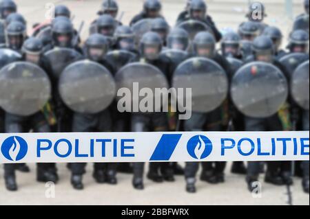 Polite/Polizeiband vor der belgischen Bereitschaftstruppe, die in Belgien eine Schutzbarriere mit Bereitschaftssiegen bildet Stockfoto