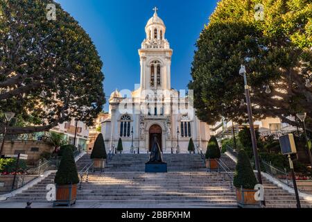 Monaco, Monte Carlo, 25. Dezember 2019: Die katholische Kirche Eglise Saint-Charles bei Sonnenuntergang, Treppen, grüne Bäume, ohne Menschen Stockfoto