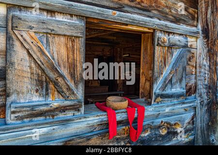 Holzfenster in einer Scheune mit einer Schüssel und einem roten Schal Stockfoto