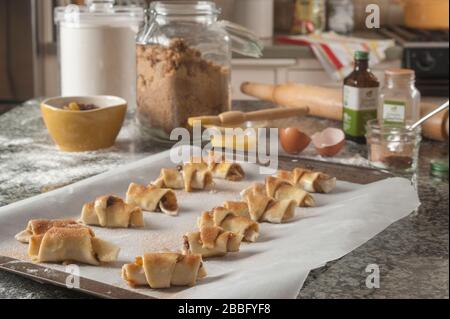 Ruglelacher Backwaren auf Pergament gefüttertem Backblech auf Granit-Insel in der Küche. Stockfoto