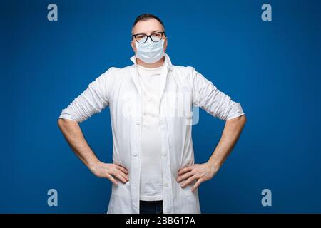 Erwachsener Arzt, der in einer Gesichtsmaske im Studio steht Stockfoto