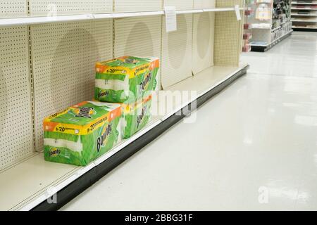 Indiana, USA - 24. März 2020: Drei Pakete mit Papiertüchern verbleiben in ansonsten leeren Regalen im Zielladen, wo Schilder angebracht werden, die p begrenzen Stockfoto