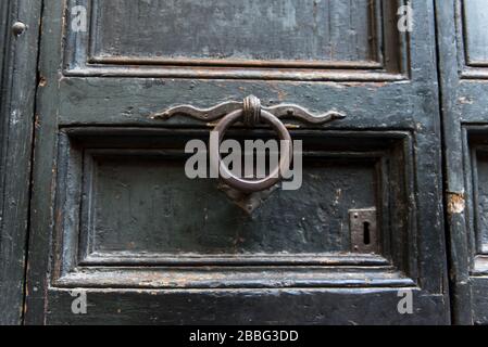 Ein alter Metallklopfer an einer alten Holztür Stockfoto