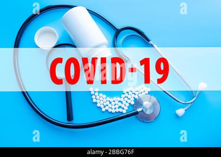 COVID-19-Text mit Stethoskop und Blutprobenvakuumschlauch auf schwarzem Hintergrund. Covid-19 oder Coronavirus Konzept Stockfoto