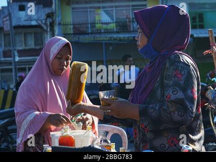 Makassar, Indonesien. März 2020. Die Einwohner trinken von Händlern in Makassar, South Sulawesi, Indonesien, am 31. März 2020 verkaufte Kräuter. Gesundheitsgetränke aus pflanzlichen Zutaten erhöhen die Immunität gegen die Kovid-19. Derzeit gibt es 724.565 Fälle von Corona-Virus in 199 Ländern, die zu globalen Pandemiefällen geworden sind. (Foto von Ali Fahmi/INA Photo Agency/Sipa USA) Credit: SIPA USA/Alamy Live News Stockfoto