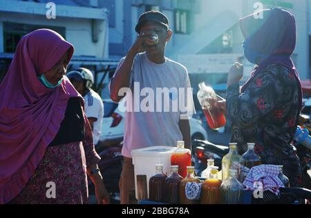 Makassar, Indonesien. März 2020. Die Einwohner trinken von Händlern in Makassar, South Sulawesi, Indonesien, am 31. März 2020 verkaufte Kräuter. Gesundheitsgetränke aus pflanzlichen Zutaten erhöhen die Immunität gegen die Kovid-19. Derzeit gibt es 724.565 Fälle von Corona-Virus in 199 Ländern, die zu globalen Pandemiefällen geworden sind. (Foto von Ali Fahmi/INA Photo Agency/Sipa USA) Credit: SIPA USA/Alamy Live News Stockfoto