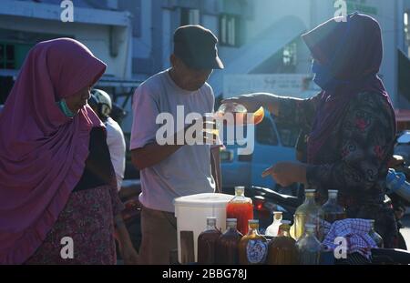 Makassar, Indonesien. März 2020. Die Einwohner trinken von Händlern in Makassar, South Sulawesi, Indonesien, am 31. März 2020 verkaufte Kräuter. Gesundheitsgetränke aus pflanzlichen Zutaten erhöhen die Immunität gegen die Kovid-19. Derzeit gibt es 724.565 Fälle von Corona-Virus in 199 Ländern, die zu globalen Pandemiefällen geworden sind. (Foto von Ali Fahmi/INA Photo Agency/Sipa USA) Credit: SIPA USA/Alamy Live News Stockfoto