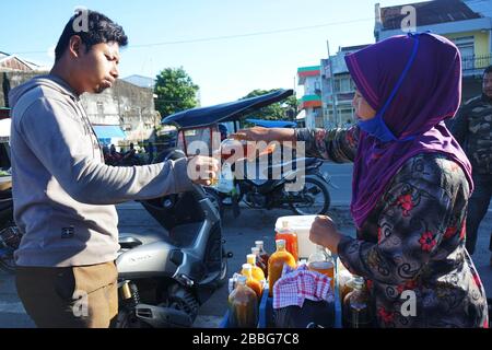 Makassar, Indonesien. März 2020. Ein Mann trinkt gesunde Kräuter, die von Händlern in Makassar, South Sulawesi, Indonesien, am 31. März 2020 verkauft werden. Gesundheitsgetränke aus pflanzlichen Zutaten erhöhen die Immunität gegen die Kovid-19. Derzeit gibt es 724.565 Fälle von Corona-Virus in 199 Ländern, die zu globalen Pandemiefällen geworden sind. (Foto von Ali Fahmi/INA Photo Agency/Sipa USA) Credit: SIPA USA/Alamy Live News Stockfoto