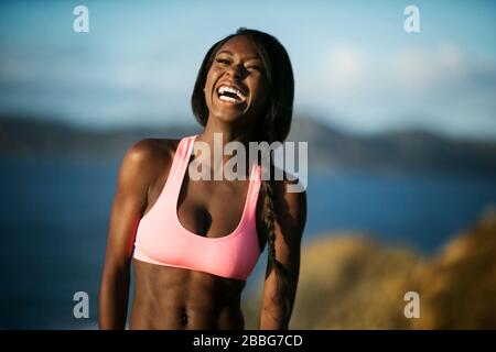 Lachende junge Frau, die ein Oberteil trägt. Stockfoto